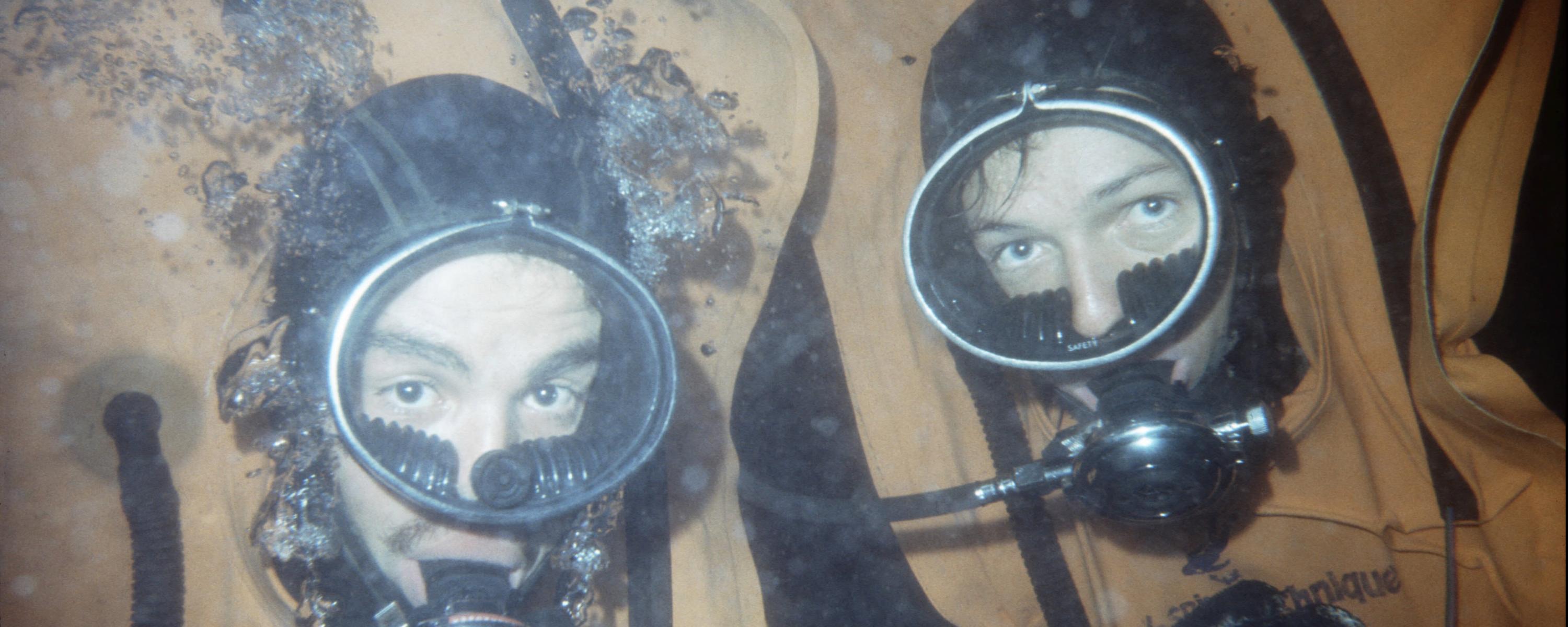 Zwei Armeetaucher blicken unter Wasser in die Kamera