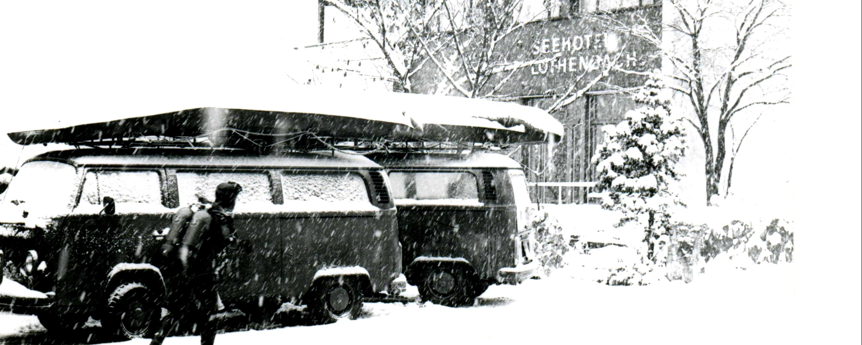 Ein Taucher im Tauchanzug läuft durch knietiefen Schnee